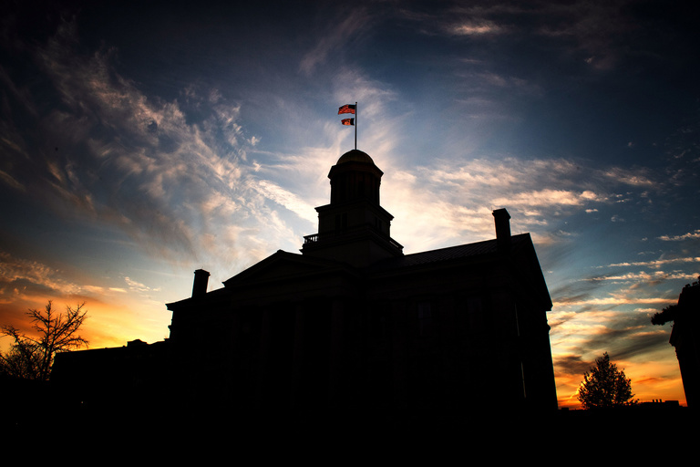 Old capitol silhouetted against a sunset sky.
