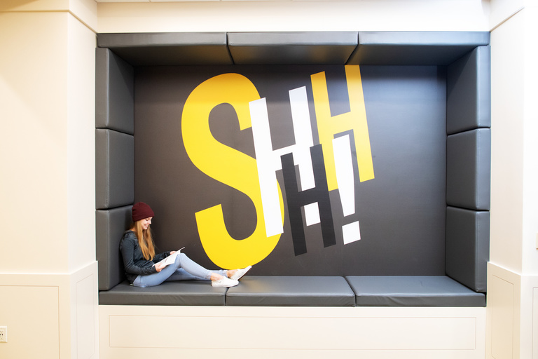 Large stylized black and gold type reads "Shhh!" in the back of a student study nook