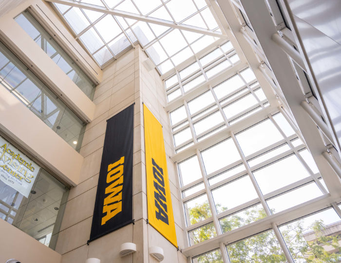 Black and gold banners display the block IOWA logo in an atrium space