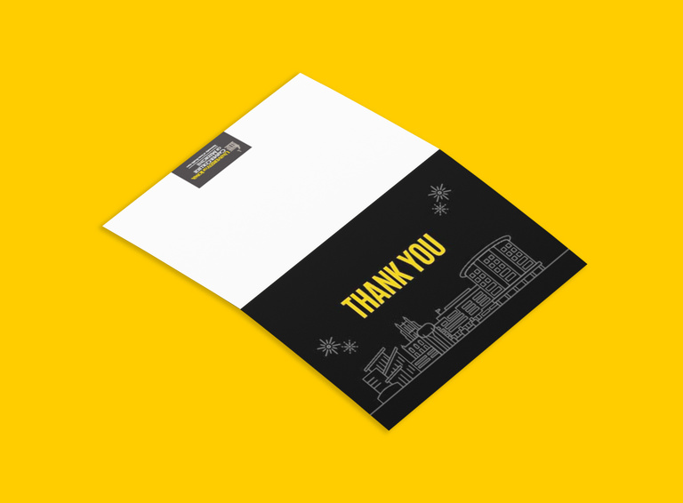 Folded thank you card shown flat. Illustration of recognizable Iowa healthcare buildings on a black background with gold text that reads "Thank You"