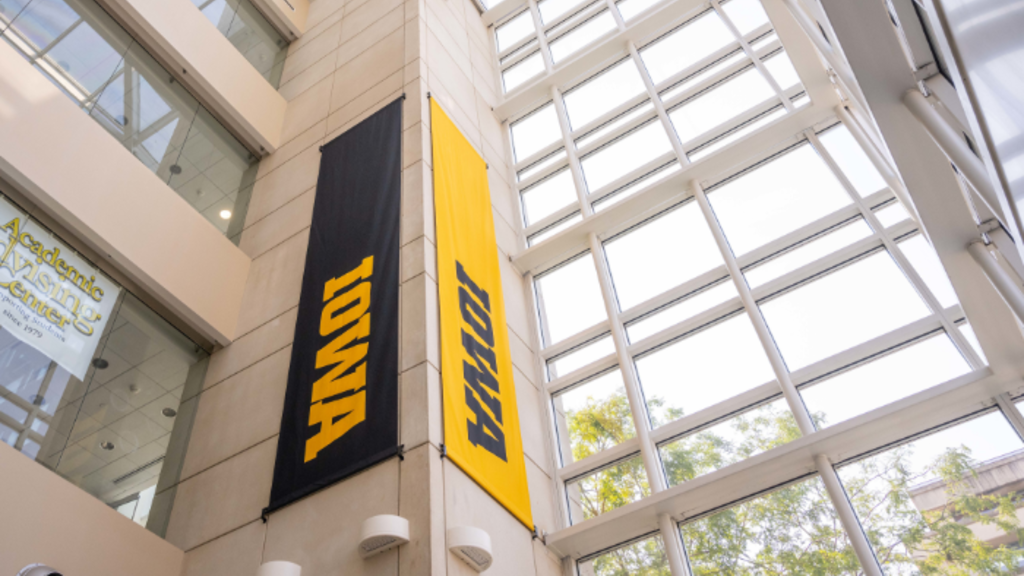 Black and gold banners display the block IOWA logo in an atrium space